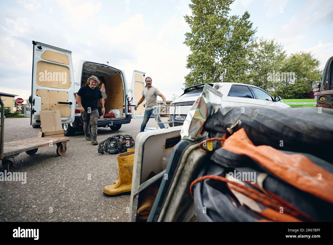 Regensburg, Germany. 07th June, 2023. Together with driver Willi Brüggemann (r), his wife Hanni and their children, Michael Buschheuer packs a van with aid supplies for Ukraine. He organizes the aid with his relief organization 'space eye'. Among other things, the transport brings life jackets, rubber boots, blankets, survival suits and sleeping bags to the war-torn country. Credit: Tobias C. Köhler/dpa/Alamy Live News Stock Photo