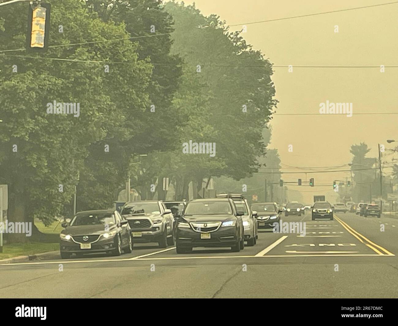 A hazy sky, caused by wildfires, creates low visibility and hazardous and unhealthy conditions in a suburban town Stock Photo