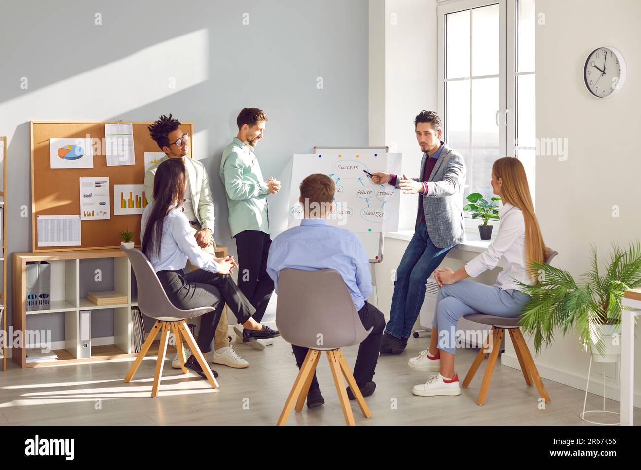 Male coach giving presentation for employees in office Stock Photo