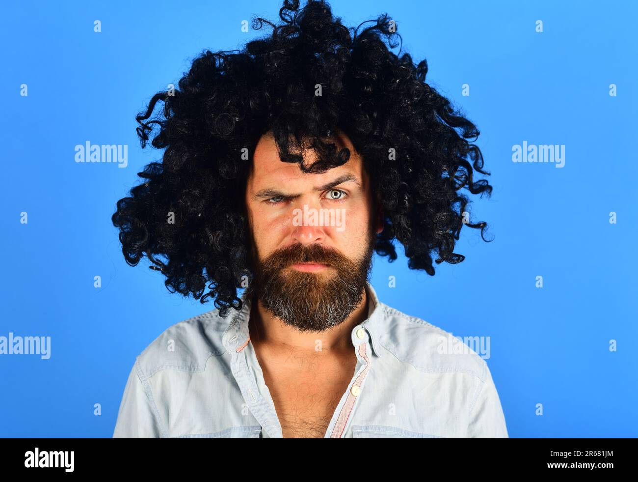 Serious bearded man in black wig. Man with beard and mustache in curly wig. Bearded hipster in black curly afro wig. Male in periwig. Party time Stock Photo