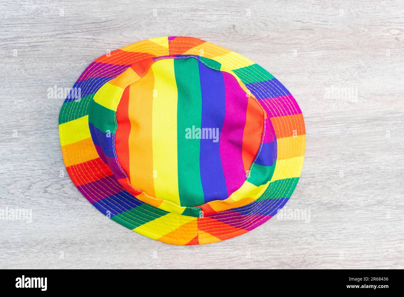 stripy rainbow striped bucket hat isolated on wood background LGBTQ gay  pride rights Stock Photo - Alamy