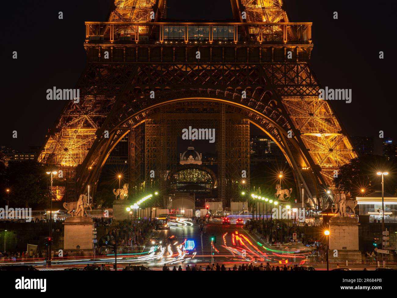 A stunning long exposure shot of car lights under the iconic Eiffel Tower illuminated at night