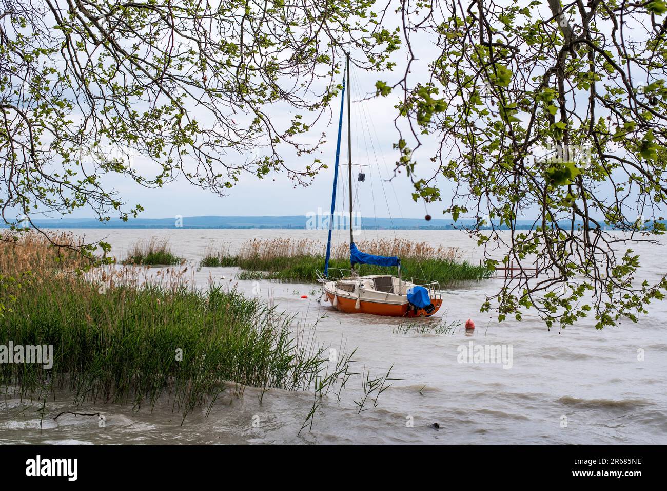 A sailboat alone waiting on Balaton lake for a coming storm to pass. Stock Photo