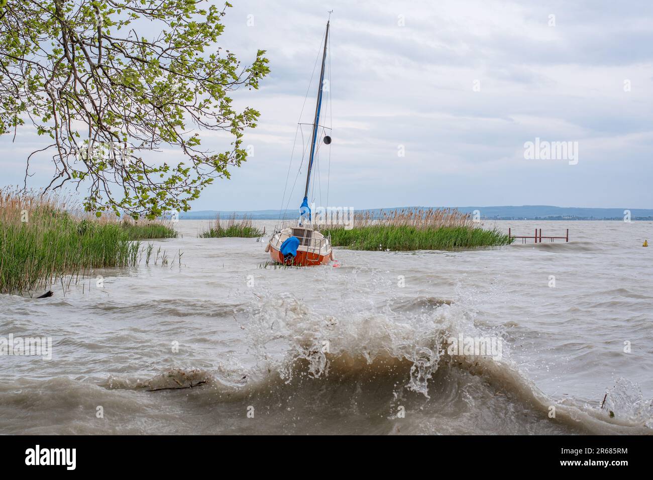 A sailboat alone waiting on Balaton lake for a coming storm to pass. Stock Photo