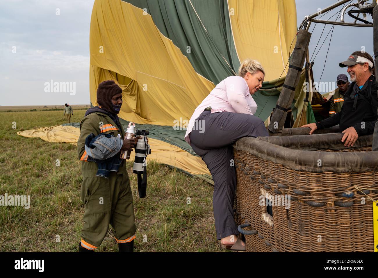 Kenya, Africa - March 10, 2023: Blonde woman struggles to climb out of the basket after a hot air balloon ride in the Masai Mara Reserve Stock Photo