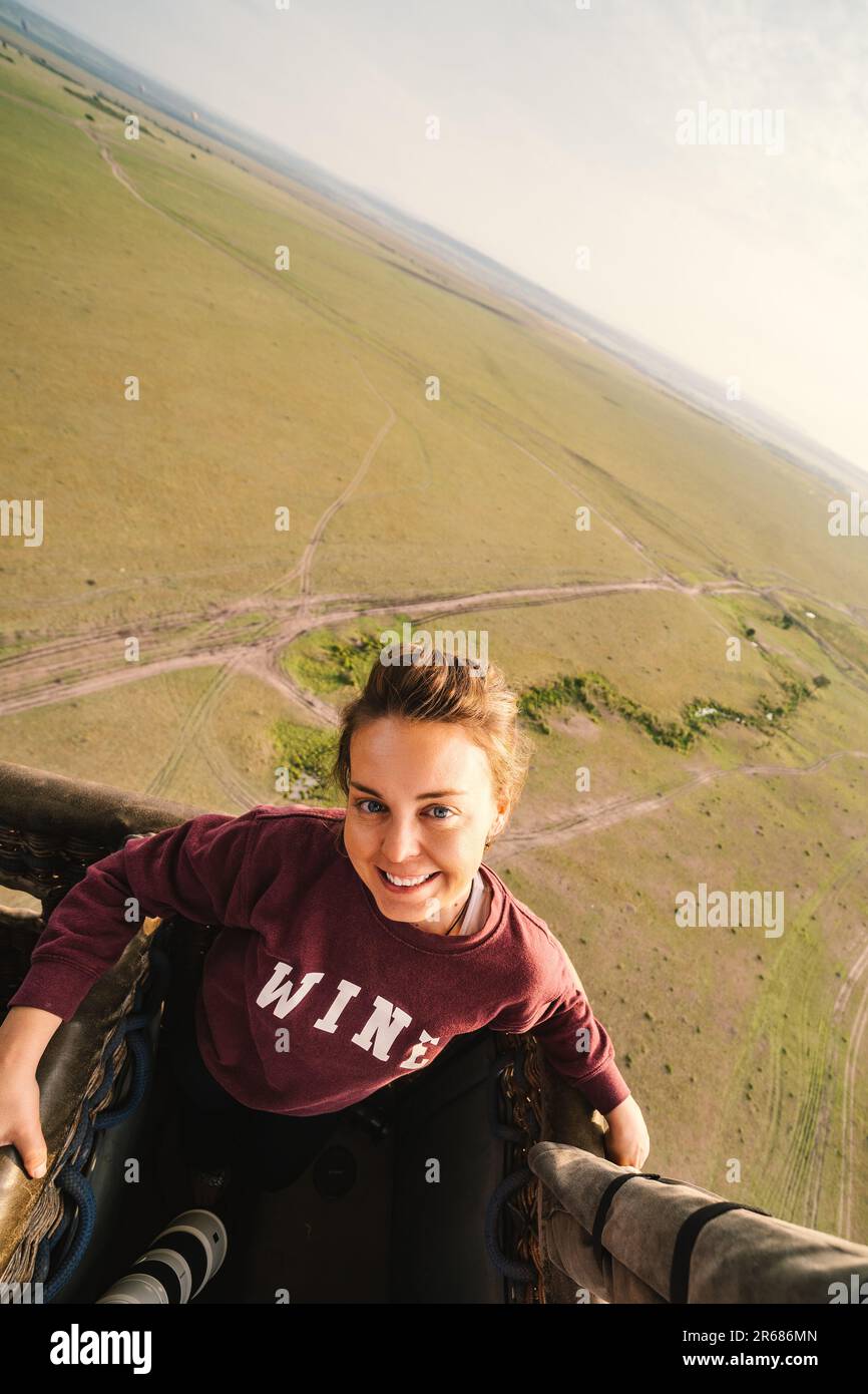 Woman smiles while on a hot air balloon safari ride in the Masai Mara Reserve in Kenya, Africa. Artistic angle of photo Stock Photo