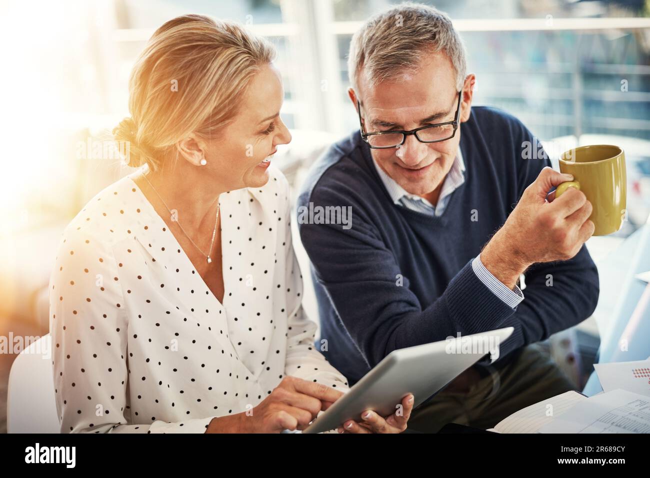 Using the smartest apps for smart budgeting. a mature couple using a digital tablet while going through paperwork at home. Stock Photo