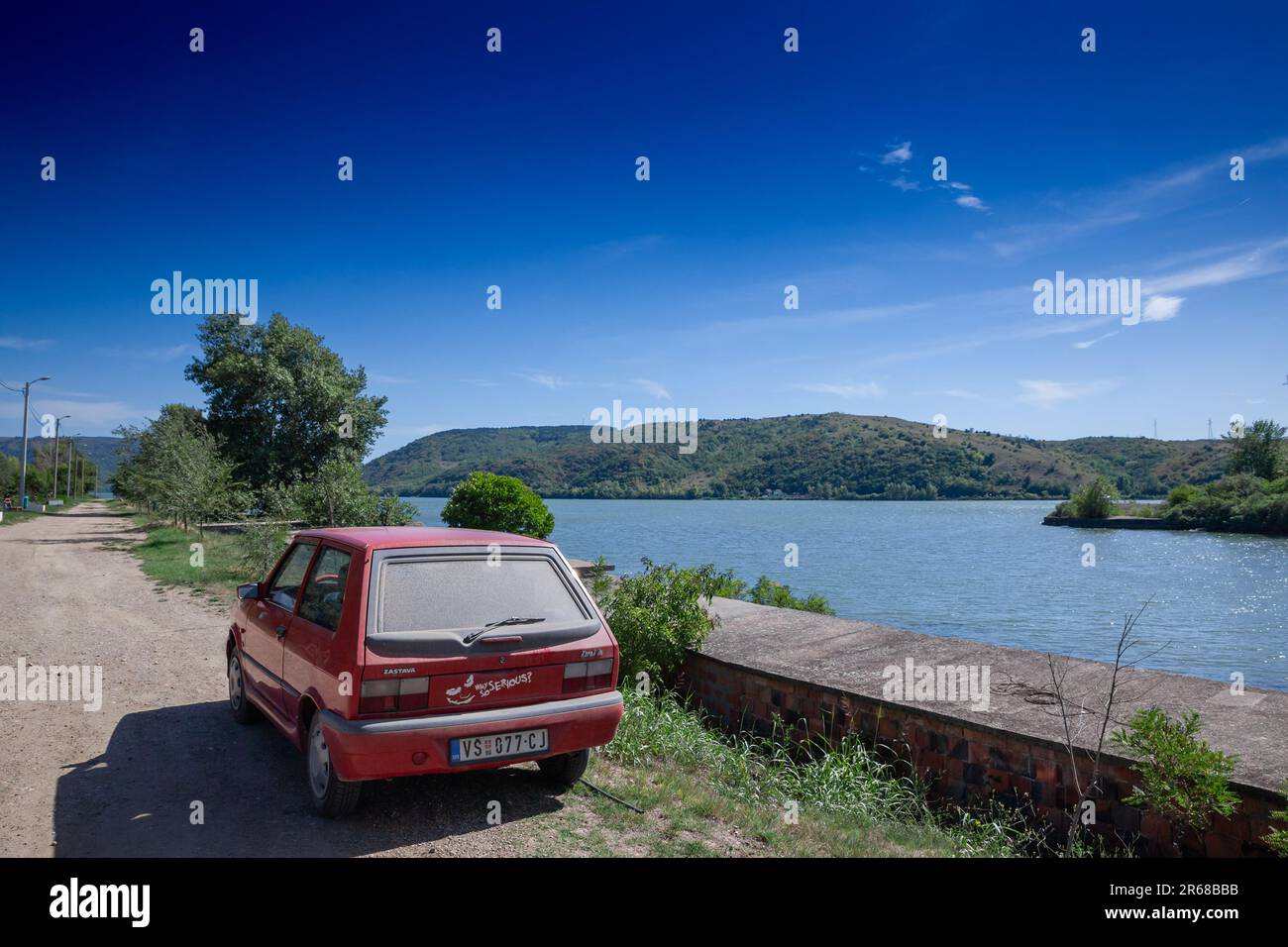 picture of a red zastava car, a yugo 45, taken in Serbia in Stara Palanka, by the iron gates and the Danube river. The Yugo also marketed as the Zasta Stock Photo