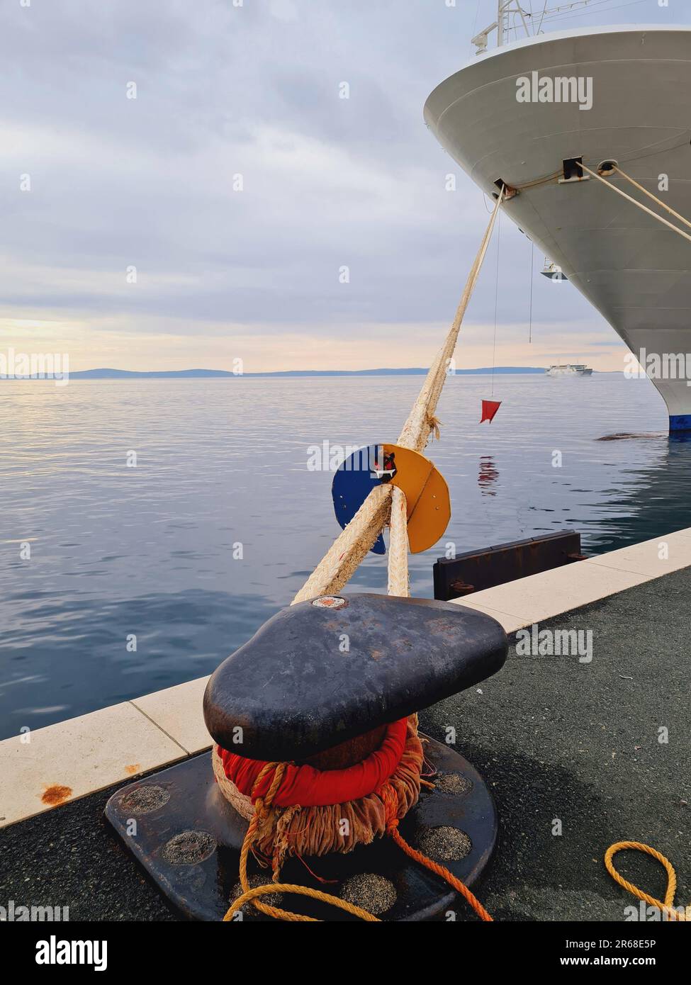 A majestic cruise ship is docked in the harbour at sunset, with large ...