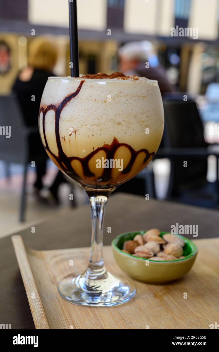 Glaass of iced frappuccino coffee with whipped cream, chocolate and ice