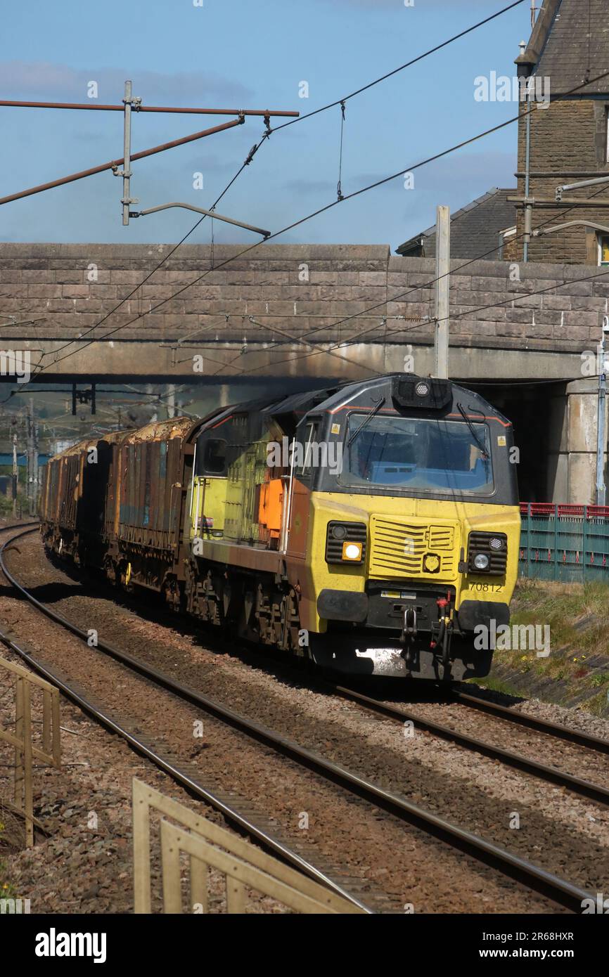 Colas Rail Freight class 70 diesel-electric loco 70812 hauling a freight (logs) train through Carnforth on the West Coast Main Line 7th June 2023. Stock Photo