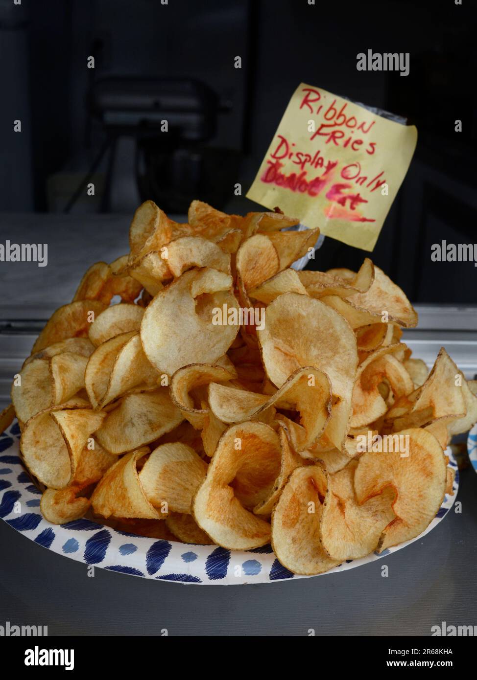 A food vendor sells ribbon fries and funnel cakes at a festival in