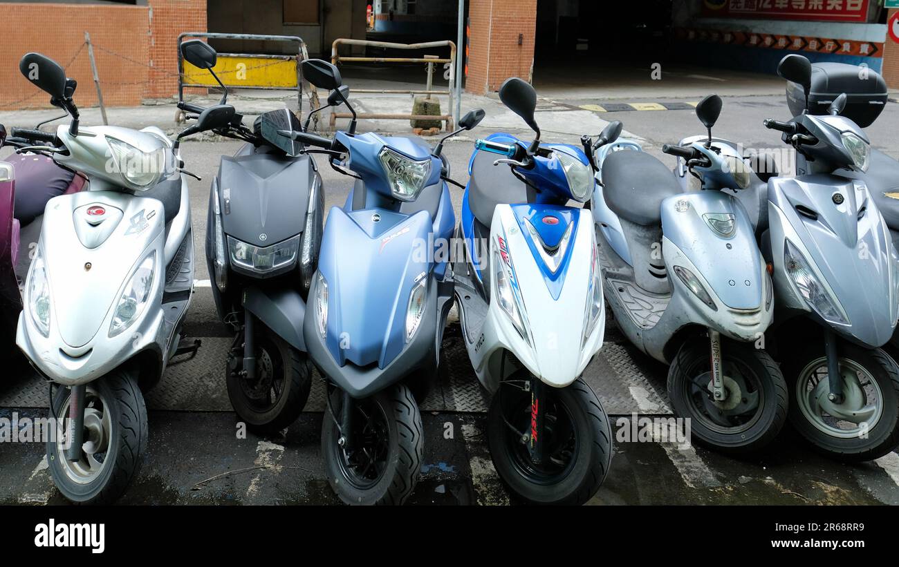 Line of parked motor scooters at a designated parking area for motorcycles and scooters; Taipei, Taiwan. Stock Photo