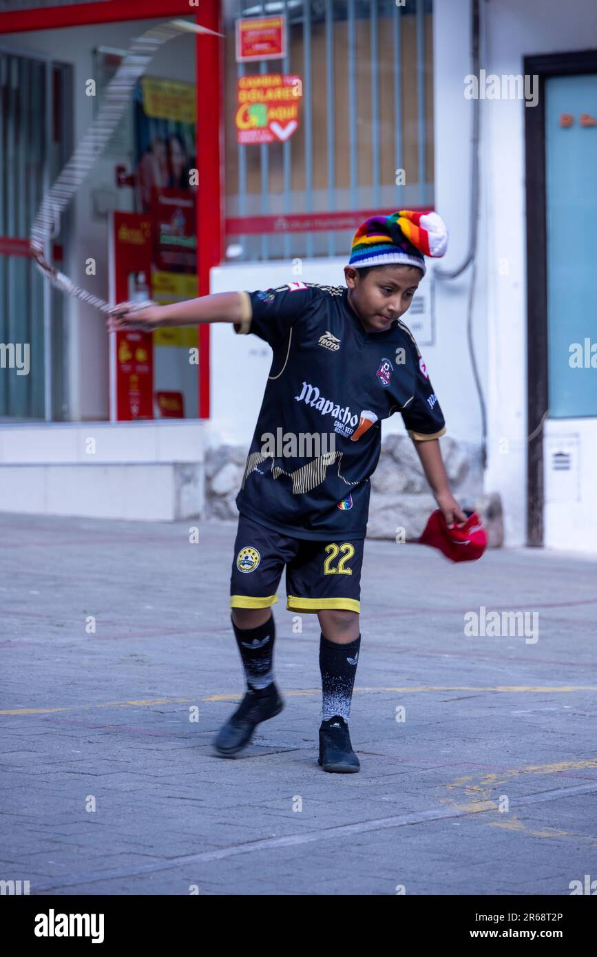 young boy playing children's game of cracking a whip, Agua Calientes, Peru Stock Photo