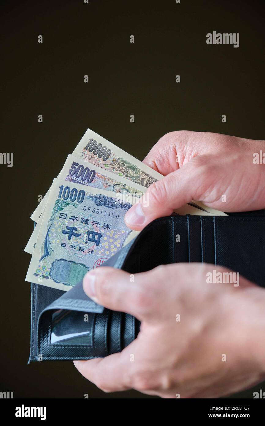 Hand holding a wallet with Japanese Yen banknotes Stock Photo Alamy