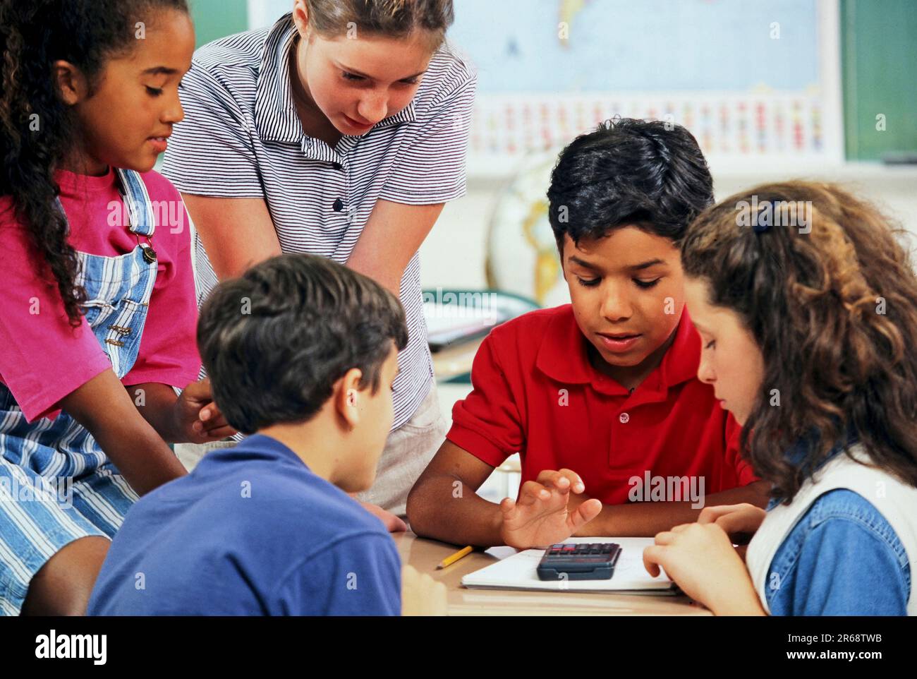 Mixed race elementary school students in math class using a calculator Stock Photo