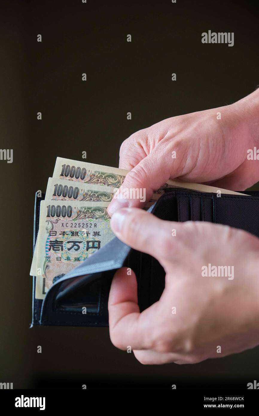 Hand holding a wallet with ten thousand yen bills Stock Photo - Alamy