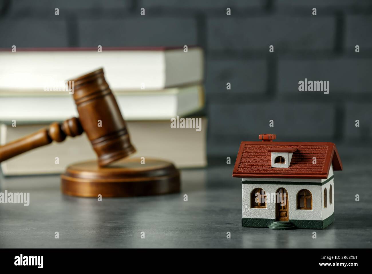 Construction and land law concepts. Judge gavel, house model with books on grey table Stock Photo