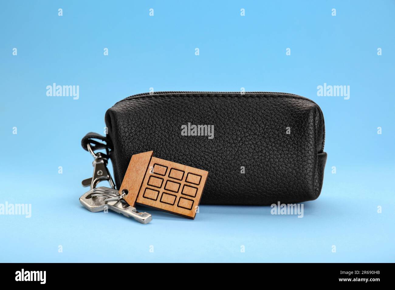 Leather case with keys on light blue background Stock Photo