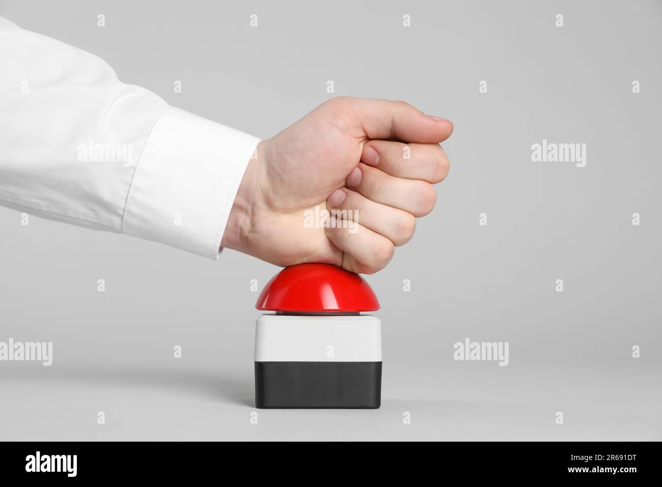 Man pressing red button of nuclear weapon on light gray background, closeup. War concept Stock Photo