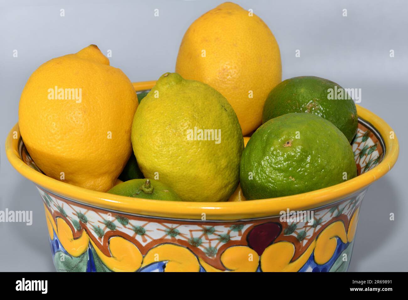Lemons and limes in a decorative ceramic bowl. Stock Photo