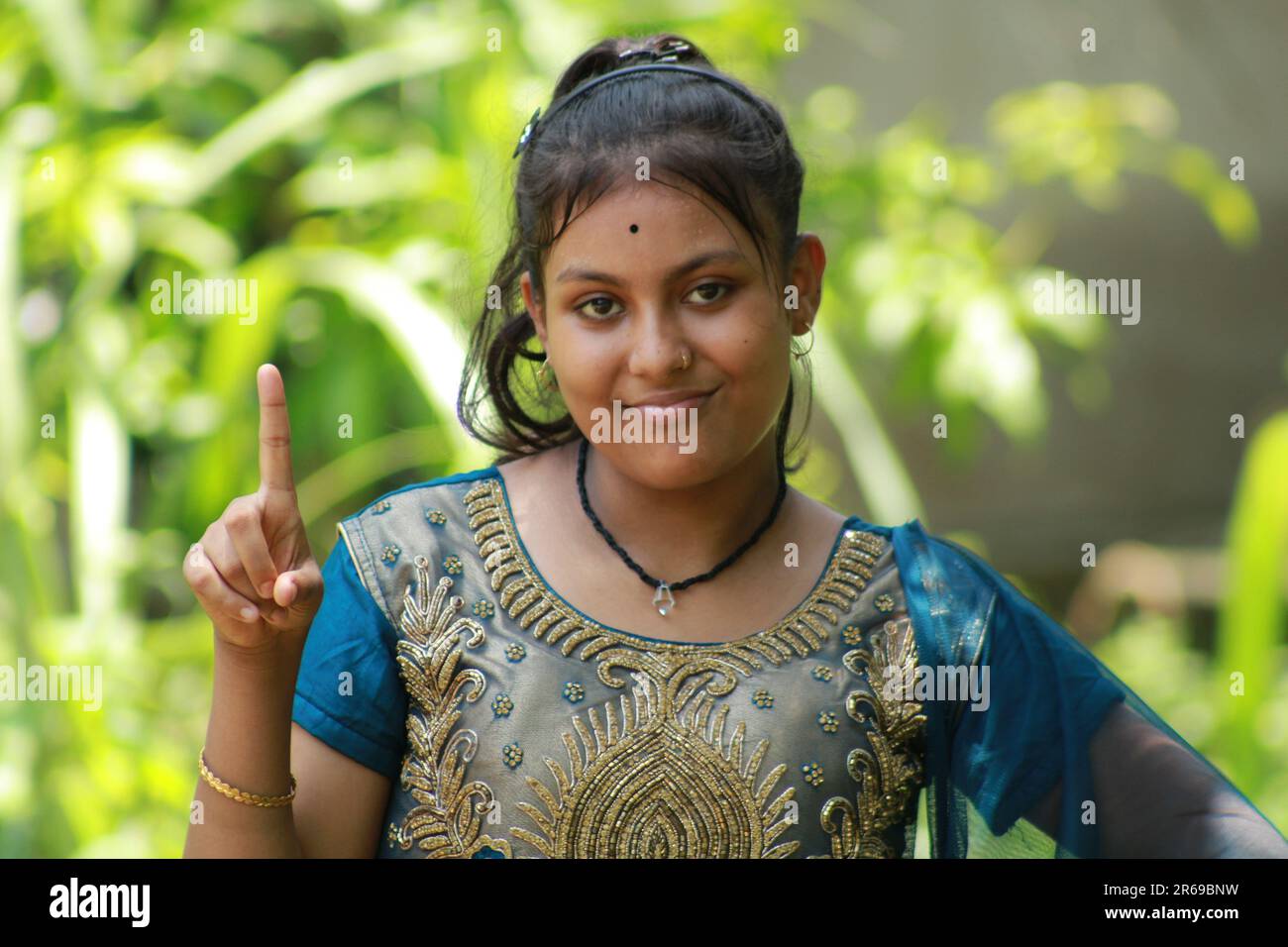 Indian Teenage Girl showing and pointing with finger number one while smiling confident and happy. Stock Photo