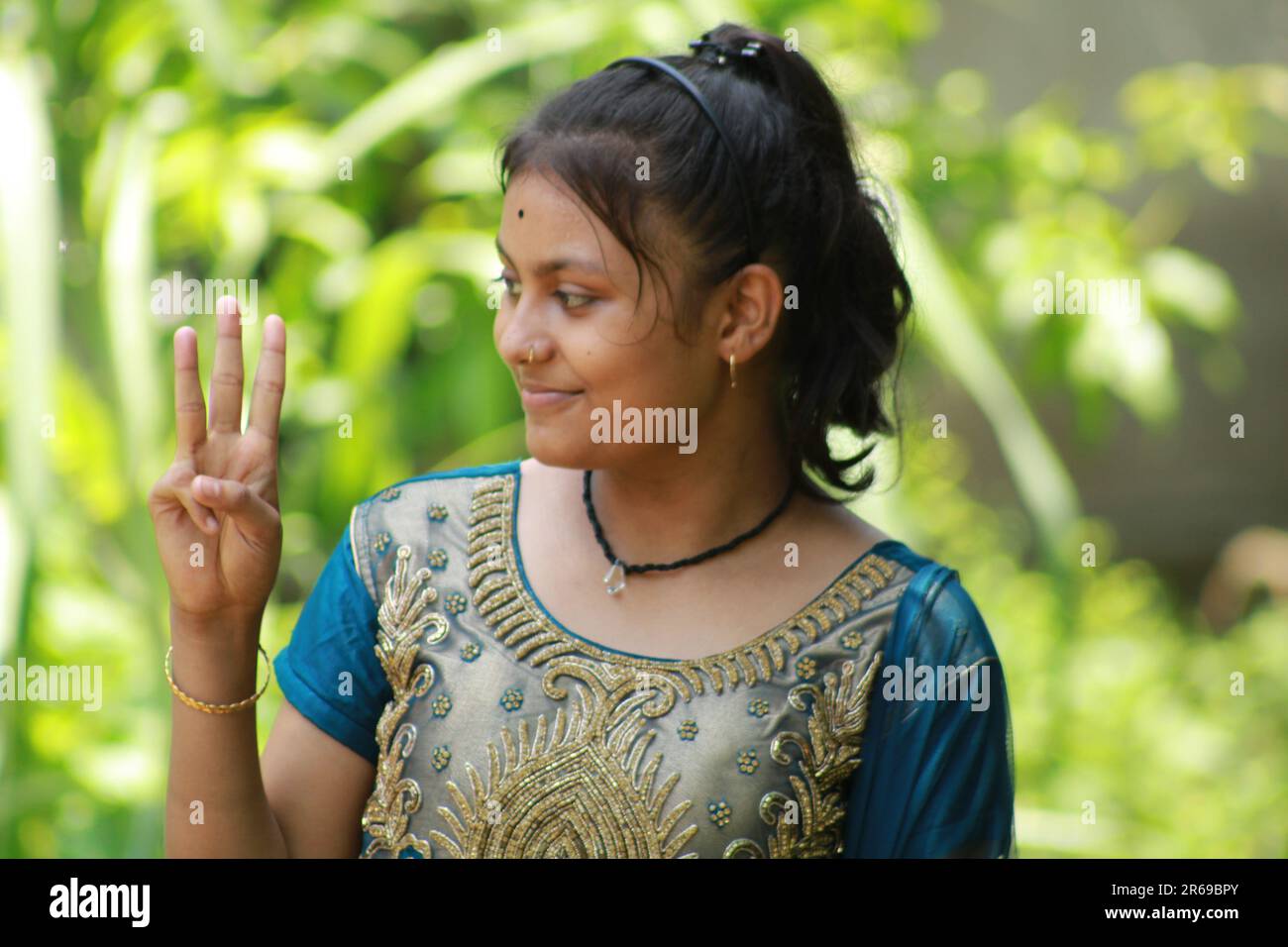 Indian Teenage Girl showing and pointing with finger number three while smiling confident and happy. Stock Photo