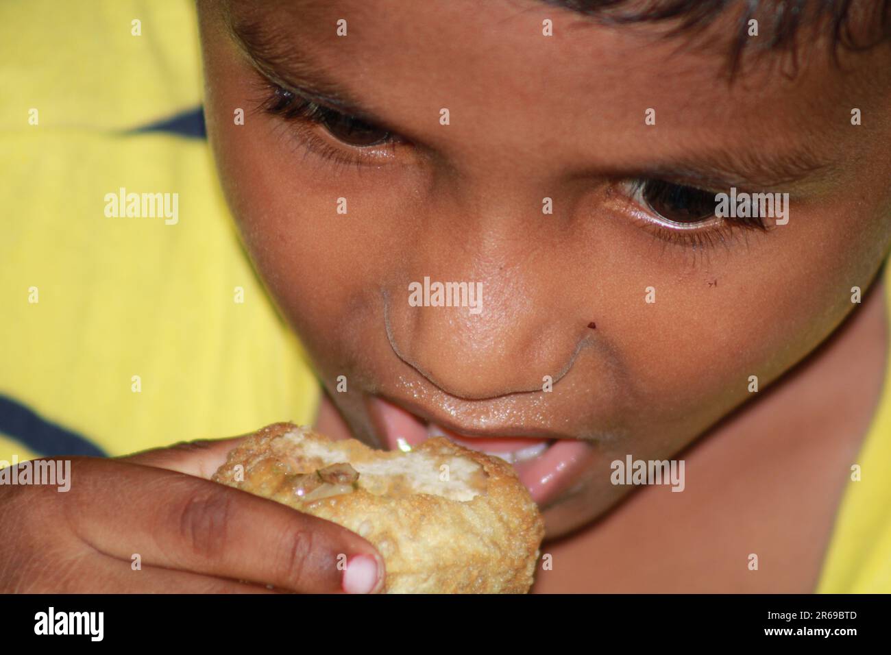 Indian little boy is opening his mouth to eat water ball Stock Photo