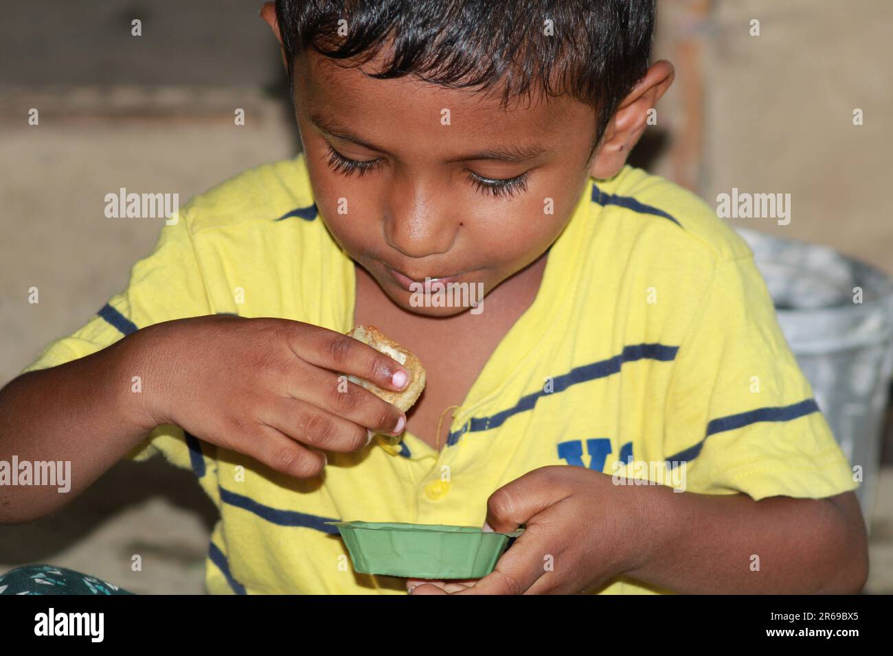 Indian little boy is opening his mouth to eat water ball Stock Photo