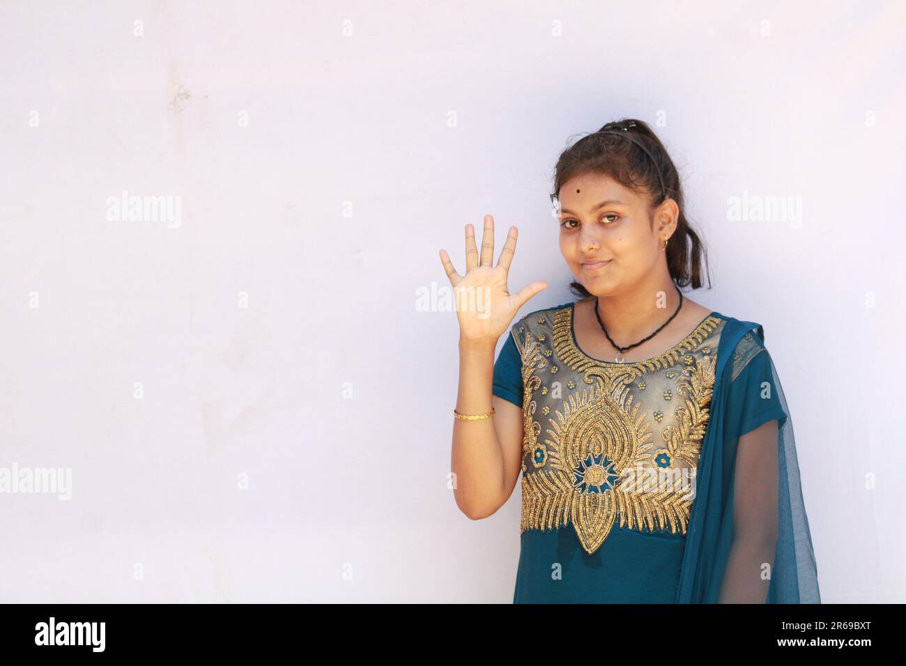 Portrait Of Beautiful Happy Indian Teenage Girl showing and pointing with finger number five while smiling confident and happy. Stock Photo