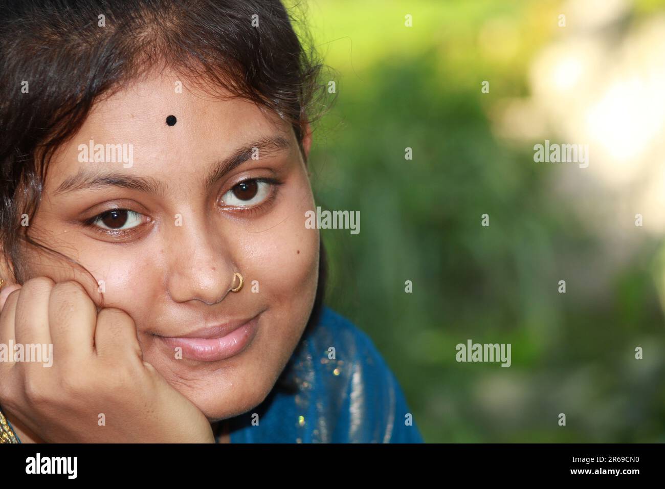 Indian Teenage girl is sitting with her hand on her cheek Stock Photo