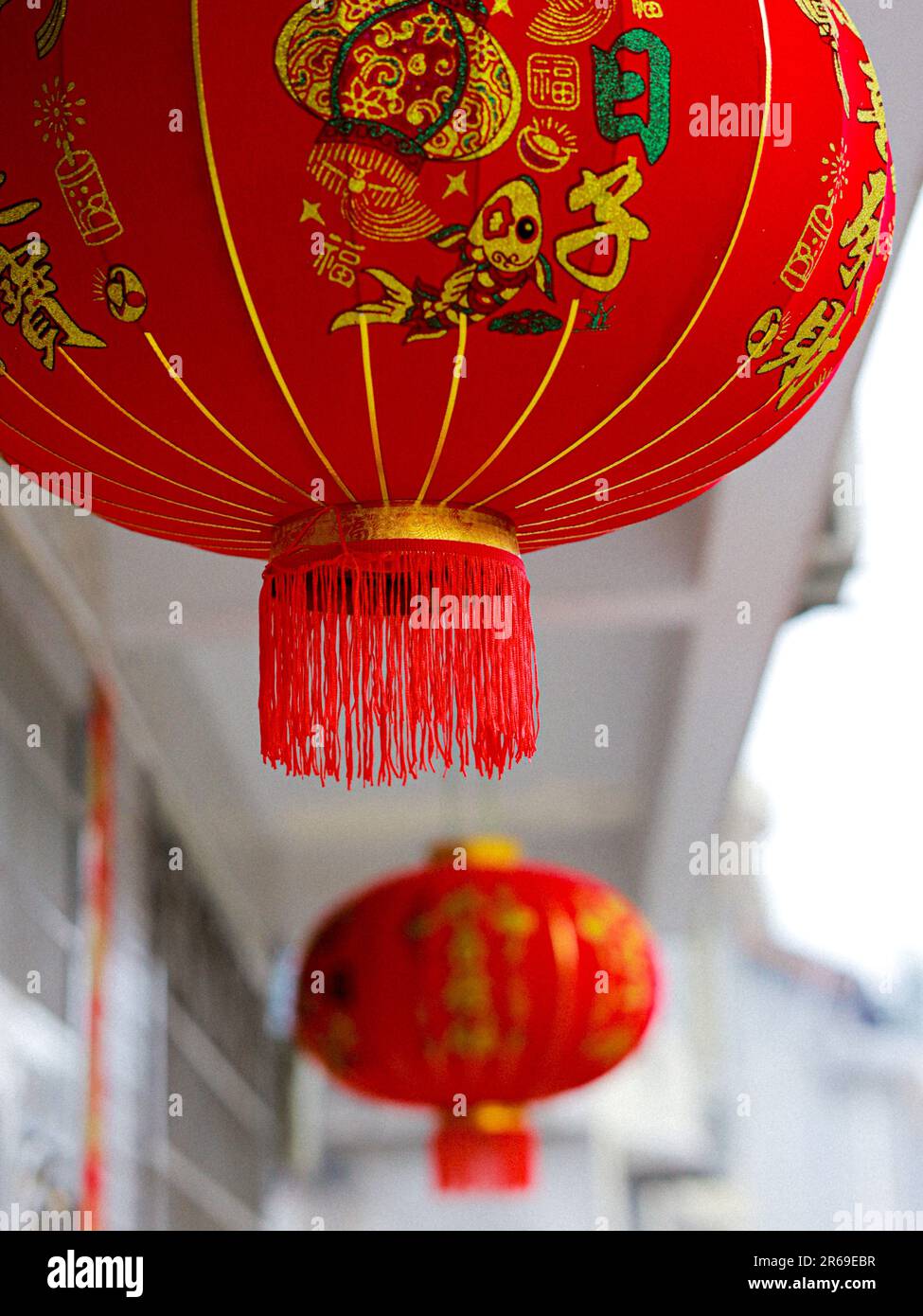 A series of red Chinese lanterns hang from a balcony Stock Photo - Alamy