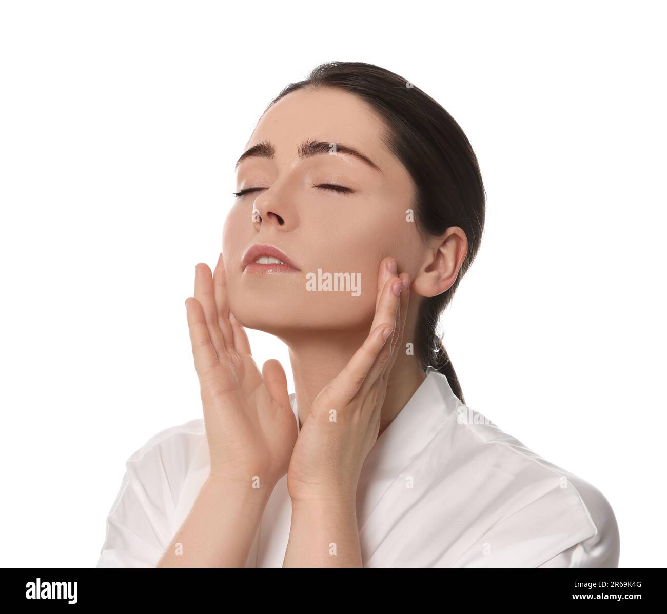 Young woman massaging her face on white background Stock Photo - Alamy