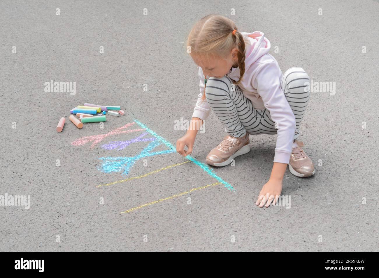 Little child drawing happy family with chalk on asphalt Stock Photo - Alamy