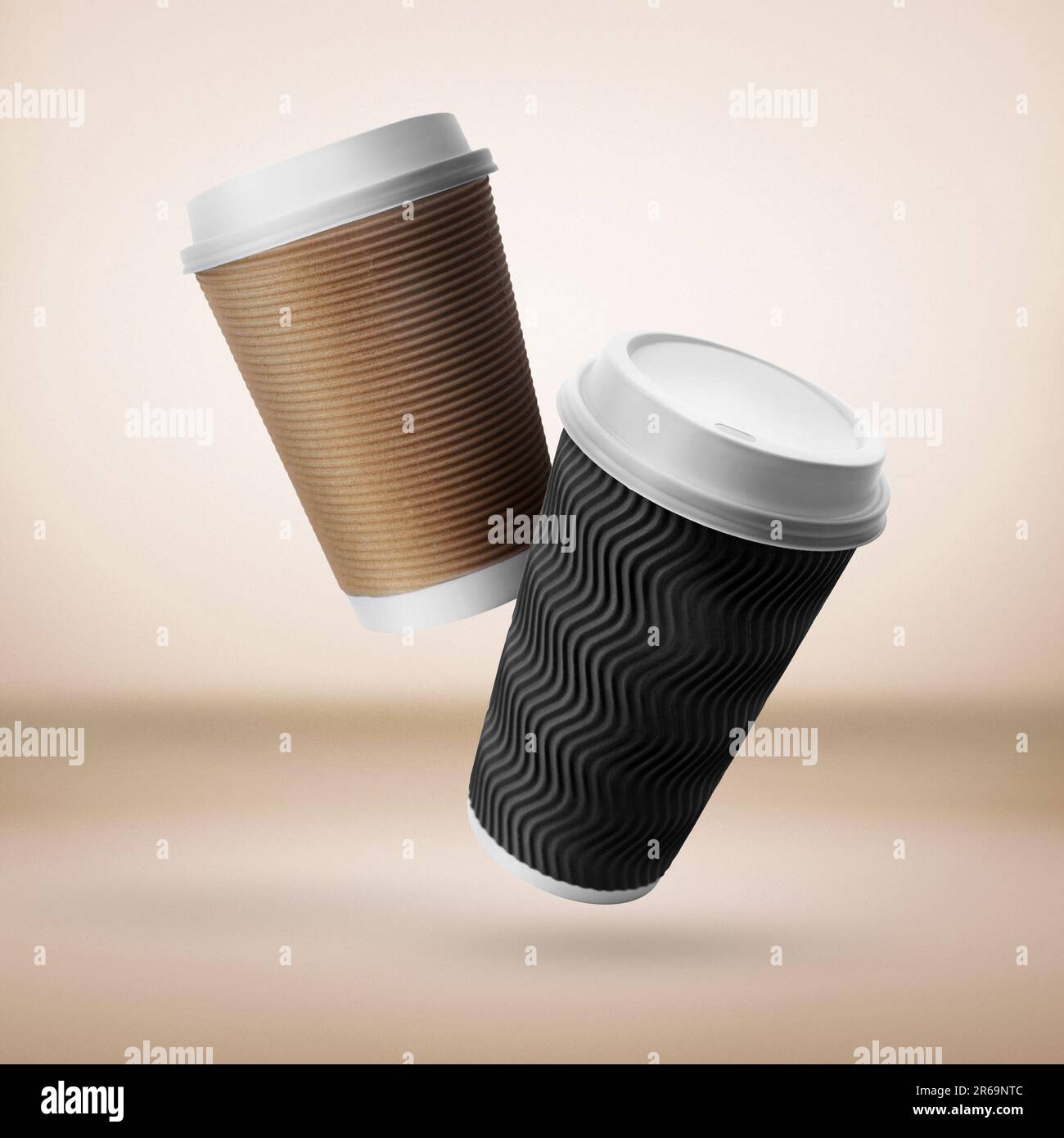 Takeaway paper cups falling on beige background Stock Photo