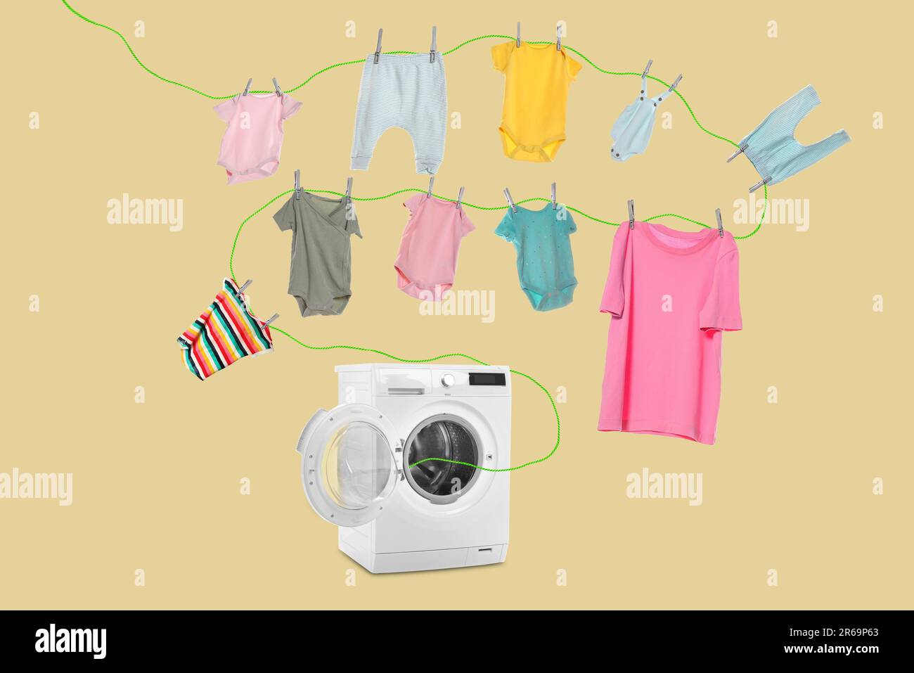 Drying laundry. Rope with children clothes flying out from washing machine on beige background Stock Photo
