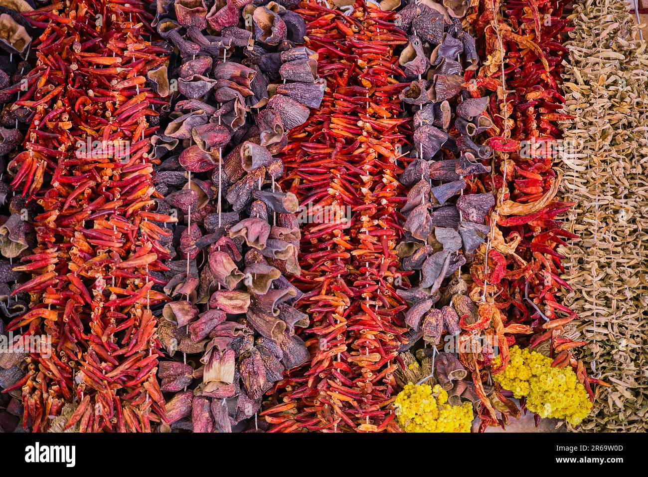 Dried vegetables at a traditional bazaar in Turkey on the Aegean coast. Dry raw red pepper, eggplant and okra hang in front of the bench Stock Photo