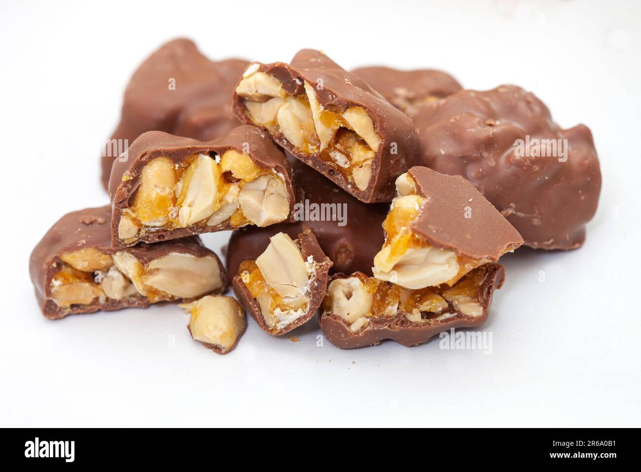 Chocolate covered peanut brittle pieces on grey, white Stock Photo Alamy