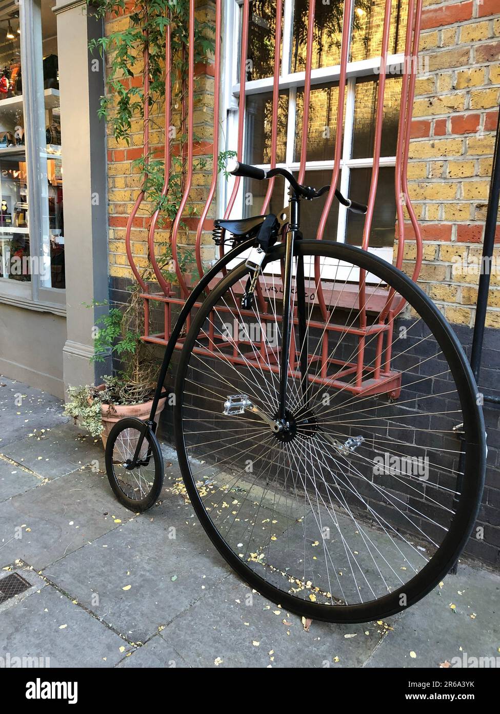A vertical of a victorian bicycle near a brick building Stock Photo