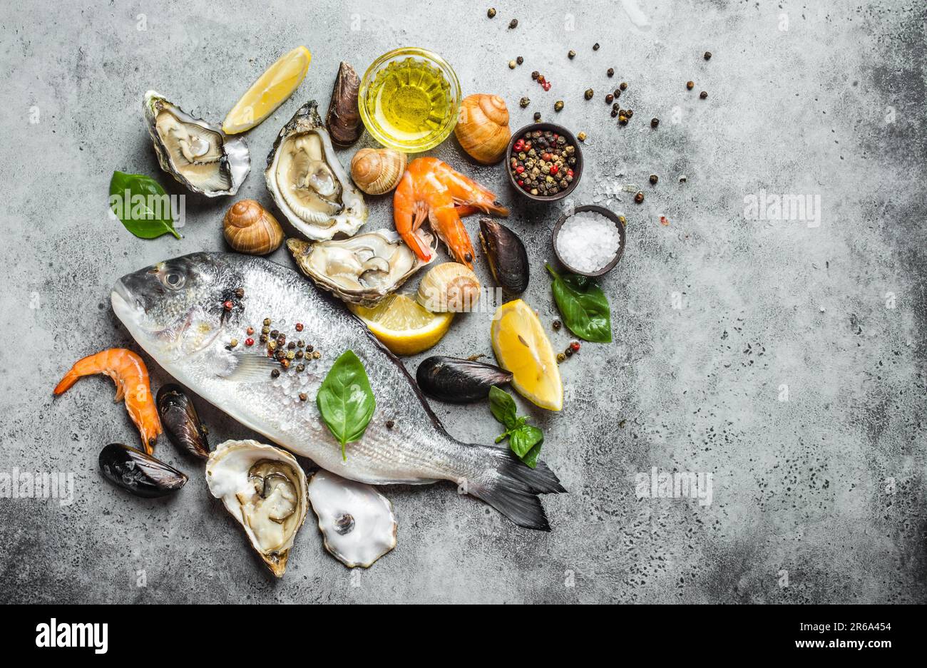 Fresh raw fish Dorado, oysters, shrimps, clams, mussels, shells with ...