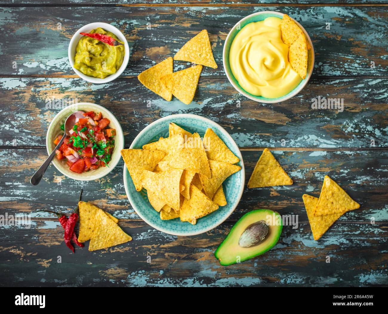 Mexican tortilla chips with guacamole, cheese, salsa dips. Nachos and