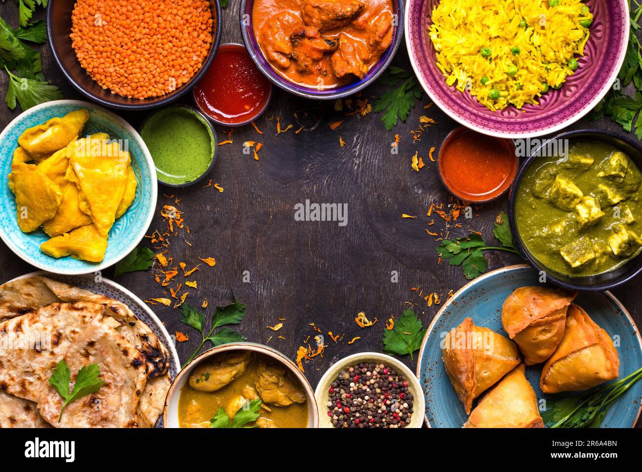 Assorted indian food on dark wooden background. Dishes of indian
