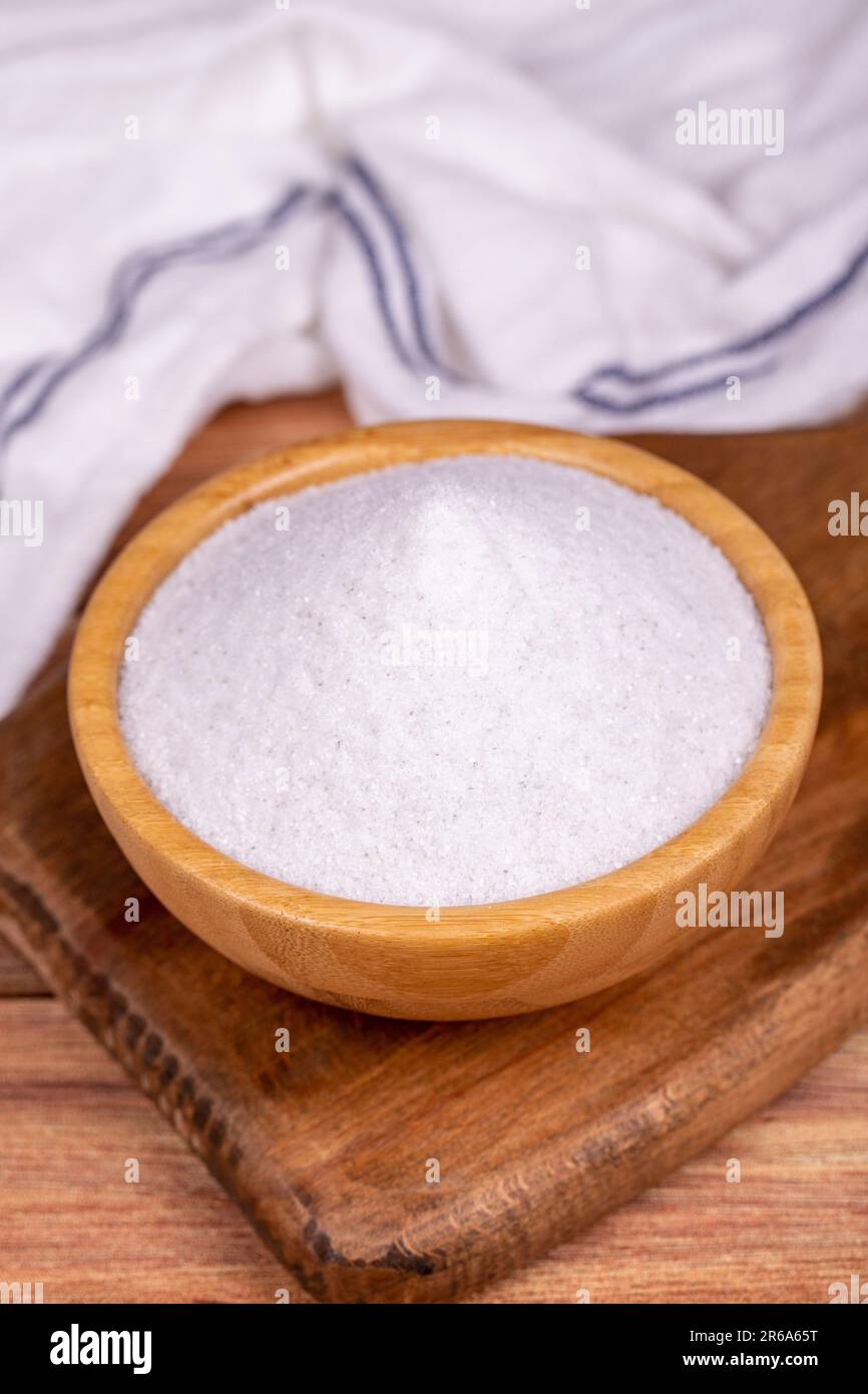 Natural minaret crystal non-iodized grinding salt on wooden background. Ground rock salt in wooden bowl Stock Photo