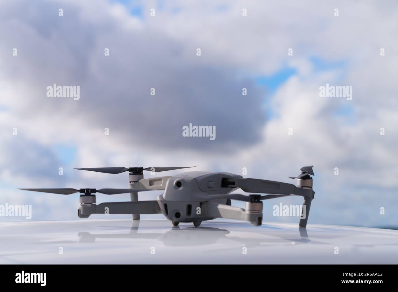 DJI Mavic Air 2 drone aircraft on car roof, with cloud background