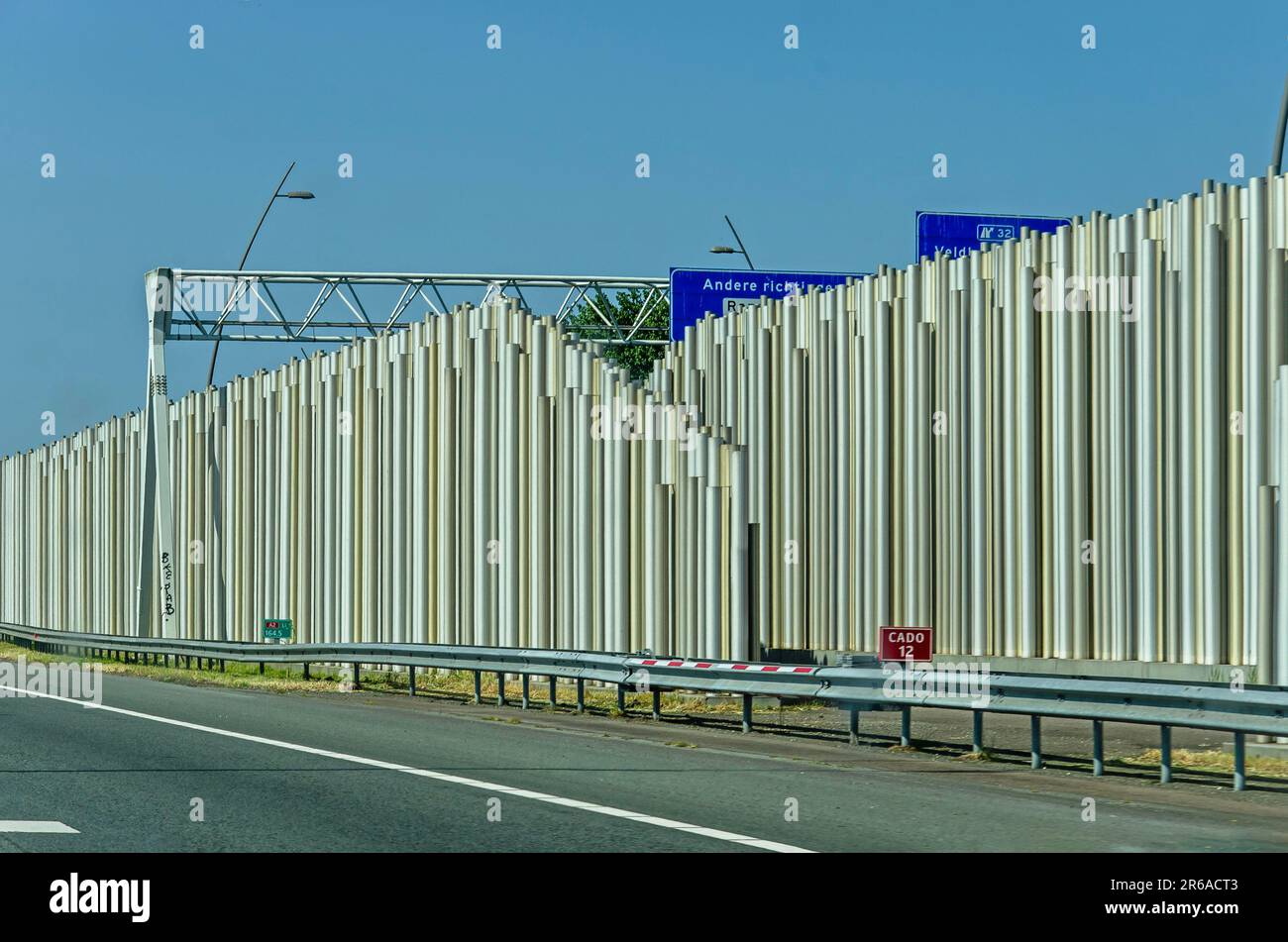 Eindhoven, The Netherlands, May 27, 2023: view from the highway towards the hi tech appearance of a sound barrier made of metallic perforated tubes Stock Photo