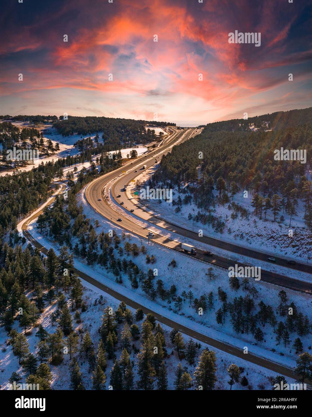 A scenic winter landscape with a road meandering through a forest of ...