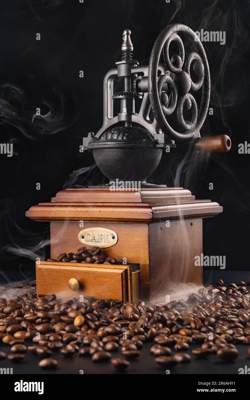 Vintage coffee grinder blender with cafe beans and aroma smoke isolated