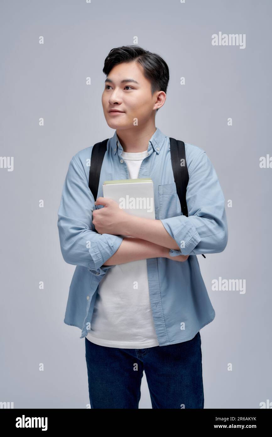 Portrait of smiling young college student with books and backpack ...