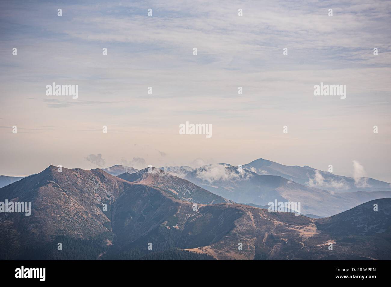 A picturesque mountain landscape with white fluffy clouds in the sky ...