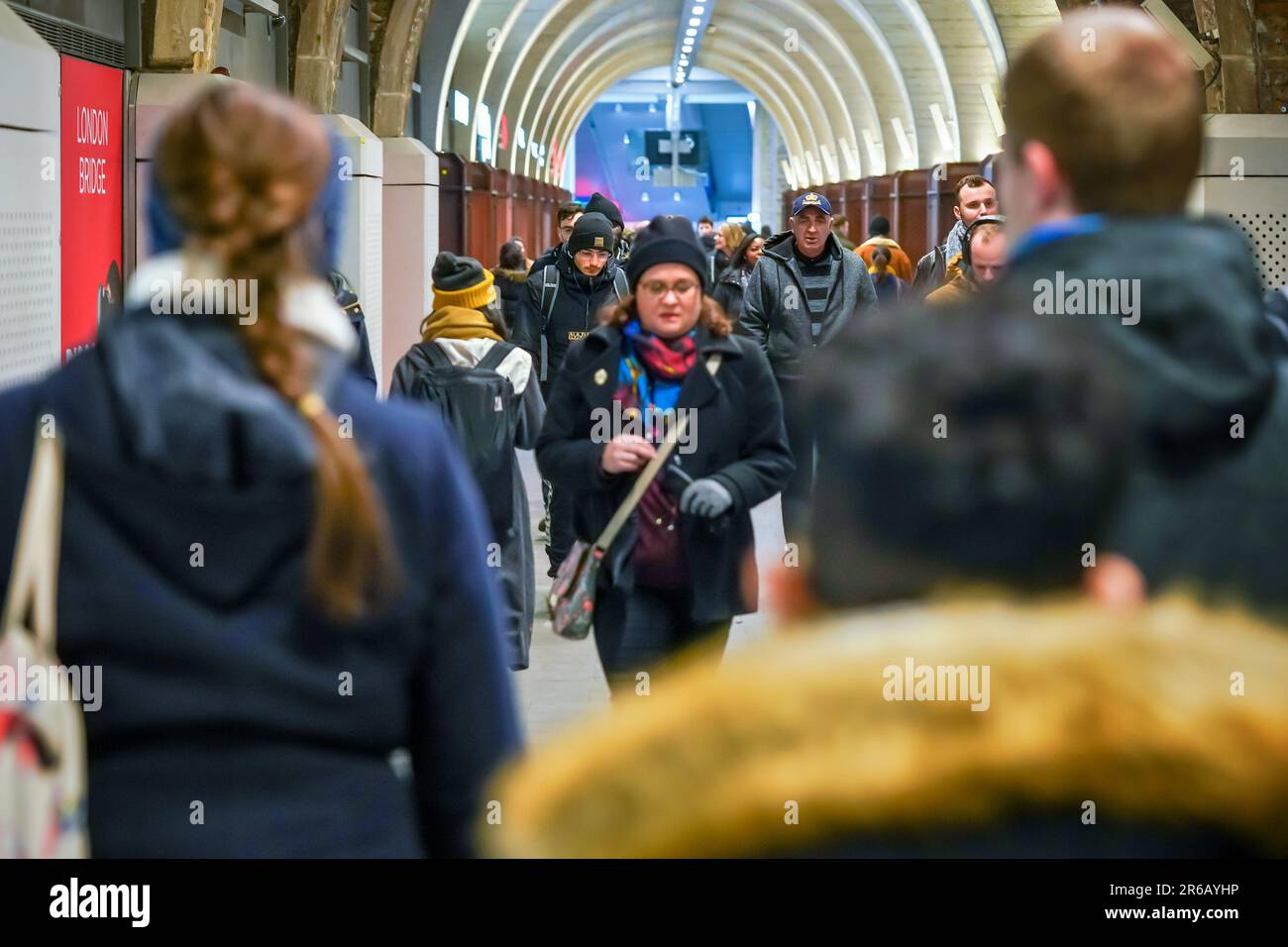 London, United Kingdom - February 02, 2019: Commuters wearing winter jackets walking in tunnel leading to London underground tube station Stock Photo